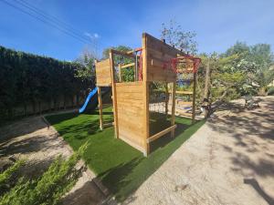 a wooden playground with a basketball hoop on grass at El Campirri in Daimés