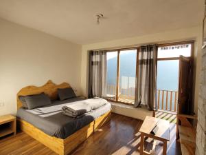 a bedroom with a bed and a large window at Samora Retreats, Manali in Vashisht +20 photos