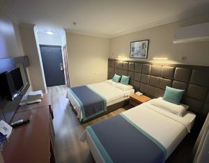 a hotel room with two beds and a television at Prima Hotel in Antalya +26 photos