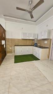 a kitchen with white cabinets and a ceiling fan at Dev And Ganga Homes in Trichūr