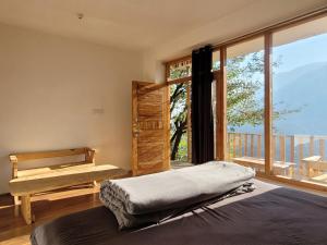 a bedroom with a bed and a large window at Samora Retreats, Manali in Vashisht