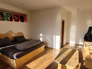 a bedroom with a bed with a wooden head board at Samora Retreats, Manali in Vashisht