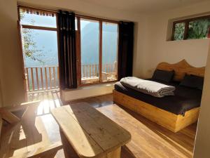 a bedroom with a bed and a large window at Samora Retreats, Manali in Vashisht