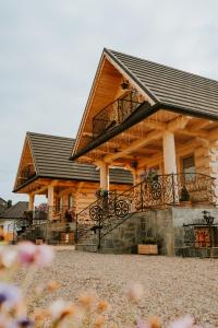 a log cabin with a balcony on a house at Dziki Raj - domki z widokiem na Tatry oraz Babią Górę in Jabłonka