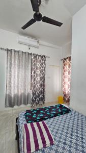 a bedroom with a bed and a ceiling fan at Dev And Ganga Homes in Trichūr +14 photos