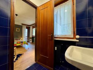 a bathroom with a sink and a room with a bed at Ampio appartamento per 8 a due passi dal centro in Bardonecchia +27 photos