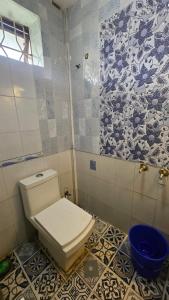 a bathroom with a toilet and a blue bowl at Dev And Ganga Homes in Trichūr