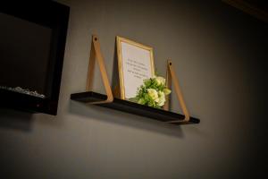 a shelf with a picture and a sign on a wall at Pasaku apartaments in Cēsis