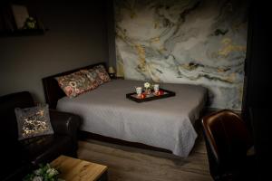 a bedroom with a bed with a tray with candles on it at Pasaku apartaments in Cēsis