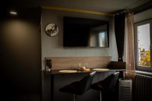 a table with two chairs and a television on the wall at Pasaku apartaments in Cēsis +24 photos