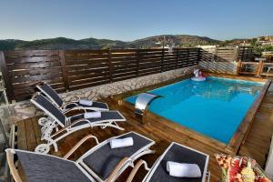a deck with chairs and a swimming pool at סוויטת אפנדי in Ya‘ara