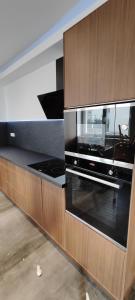 een keuken met een zwarte oven en houten kasten bij Maison moderne et chaleureuse à Colmar in Colmar