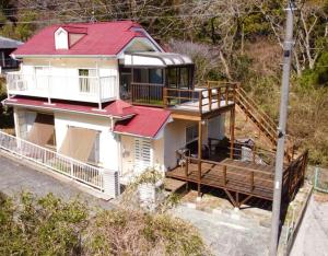 une maison blanche avec un toit rouge et une terrasse dans l'établissement Rio Grande - Vacation STAY 24026v, à Higashiizu