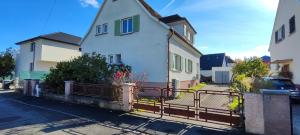 een wit huis met een hek ervoor bij Maison moderne et chaleureuse à Colmar in Colmar