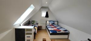 een slaapkamer op zolder met 2 bedden en een wastafel bij Maison moderne et chaleureuse à Colmar in Colmar