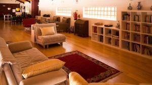 a living room with a couch and chairs and bookshelves at Casa d´Edite in Chamusca