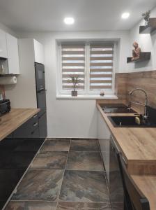 a kitchen with a sink and a window at Nina apartman in Komárno +18 photos