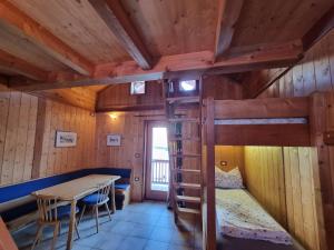 a room with a bunk bed and a table and chairs at Wieshof Schnals Bauernhofurlaub in Maso Corto