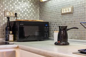 a kitchen counter with a microwave on a counter top at Harbour, the Unique Chania Old Town Apt in Chania Town +65 photos