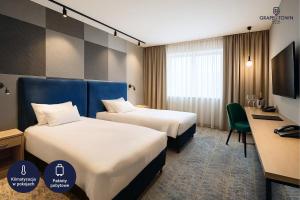 a hotel room with two beds and a desk at Grape Town Hotel - Park79 in Zielona Góra +52 photos