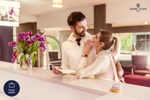 a man and a woman standing at a kitchen counter at Grape Town Hotel - Park79 in Zielona Góra