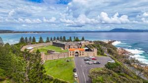 an aerial view of a building on a hill next to the ocean at Cod Place in Beautiful South West Rocks in South West Rocks