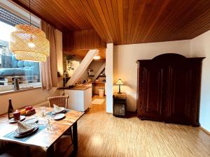 sala de estar con mesa y cocina con escalera en Ferienwohnung zum Woibauer, en Deidesheim