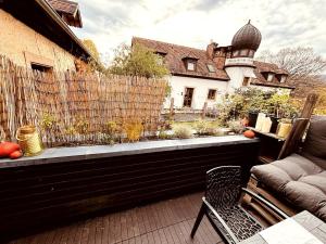 un patio con una valla, una silla y una casa en Ferienwohnung zum Woibauer, en Deidesheim 7 fotos más