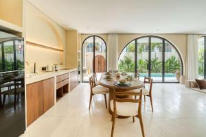 a kitchen and dining room with a table and chairs at Parisian 2BR Luxury Villa 8mins walk to Beach in Bingin Beach