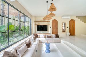 a living room with a white couch and large windows at Parisian 2BR Luxury Villa 8mins walk to Beach in Bingin Beach