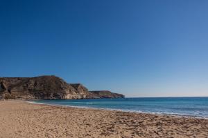 a sandy beach with rocks in the ocean at HORIA -Sundrenched apartment with terrace in Cabo de Gata in El Pozo de los Frailes