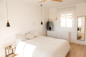a white bedroom with a bed and a mirror at HORIA -Sundrenched apartment with terrace in Cabo de Gata in El Pozo de los Frailes
