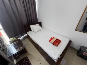 Un dormitorio pequeño con una cama con sábanas blancas. en Hotel Labbaik Farmgate, en Dhaka
