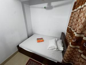 Habitación pequeña con cama con caja. en Hotel Labbaik Farmgate, en Dhaka