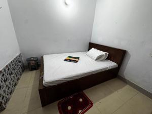 Cama pequeña en habitación pequeña con almohada en Hotel Labbaik Farmgate, en Dhaka