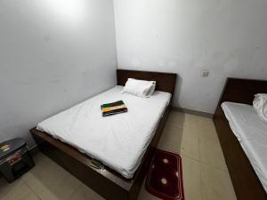 1 dormitorio pequeño con 2 camas con sábanas blancas en Hotel Labbaik Farmgate, en Dhaka