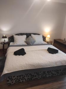 a bedroom with a large bed with two hats on it at Nina apartman in Komárno