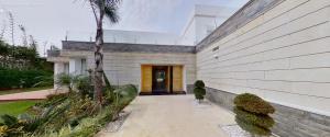 a house with a palm tree next to a building at Villa 9- luxurious 5 bedrooms villa in the heart of Ambassadors in Rabat