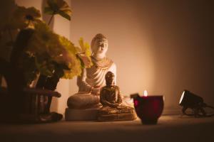 a buddha statue and a candle on a table at ROYAL CREST VILLA in Weligama