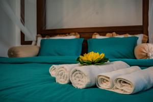 a bed with towels and a yellow flower on it at ROYAL CREST VILLA in Weligama