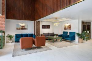 Una sala de espera con sillas azules y una mesa. en Hotel Anuttara, Boudha, en Baudhatinchule
