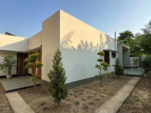 Una casa con árboles a un lado. en Veridian Villa, en Kānpur