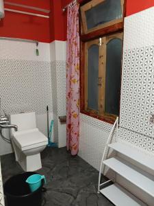 a bathroom with a toilet and a window at Bloomfield Farmhouse 2 in Darjeeling