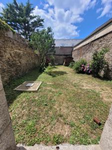 een tuin met een bakstenen muur en een tuin bij DESQ29àCONCARNEAU in Concarneau