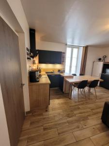een keuken met een tafel en stoelen in een kamer bij DESQ29àCONCARNEAU in Concarneau