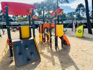 a playground with colorful play equipment in the sand at MOBIL HOME LUXUEUX 40m2 - 3ch - Camping 4 étoiles 79 - LA PIGNADE in La Tremblade