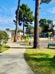 a park with trees and a sidewalk and a playground at MOBIL HOME LUXUEUX 40m2 - 3ch - Camping 4 étoiles 79 - LA PIGNADE in La Tremblade