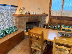 a dining room with a wooden table and a fireplace at Hostal San José in Naval +76 photos