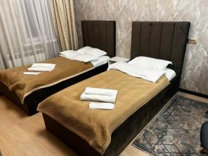 two beds sitting next to each other in a room at Hotel LION Almaty in Almaty +97 photos