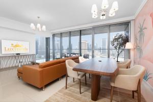 a living room with a couch and a table and chairs at Boulevard Point I Burj Khalifa Fireworks View in Dubai